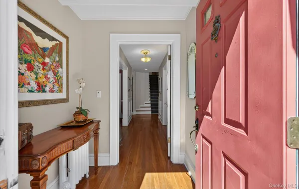 a view of a hallway with wooden floor and furniture