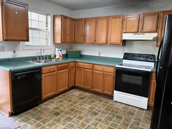a kitchen with a sink stove top oven and cabinets