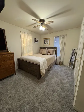 a spacious bedroom with a bed and a chandelier
