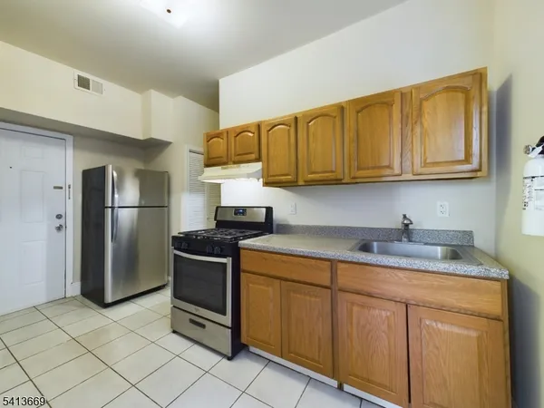 a kitchen with stainless steel appliances granite countertop a stove a refrigerator and a sink