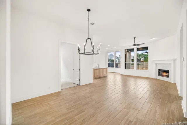 a view of a room with wooden floor fireplace and windows