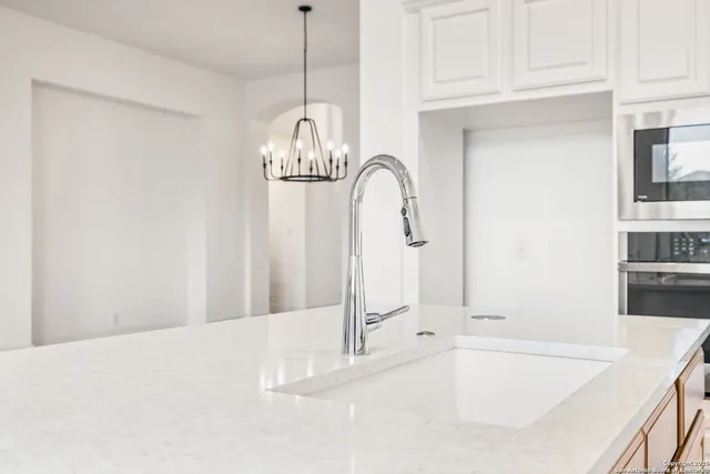 a bathroom with a bathtub and chandelier
