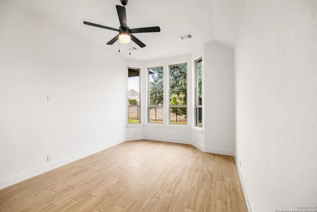 a view of room with window ceiling fan and hardwood floor