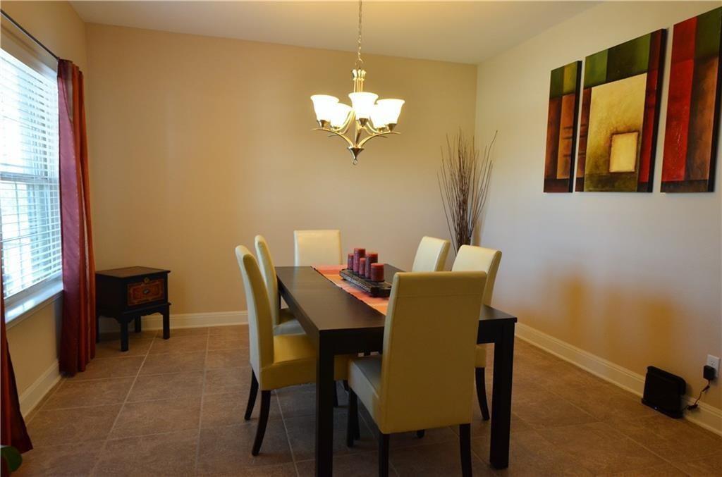 5629 Rio Chama Cove Austin, TX 78738 - Photo 6 of 34 A well-lit dining area features tiled floors and a charming chandelier, perfect for intimate gatherings.
