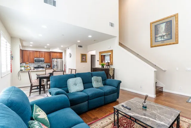 a living room with furniture kitchen view and a chandelier