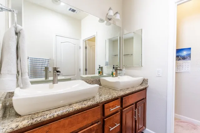 a bathroom with a granite countertop sink and a mirror