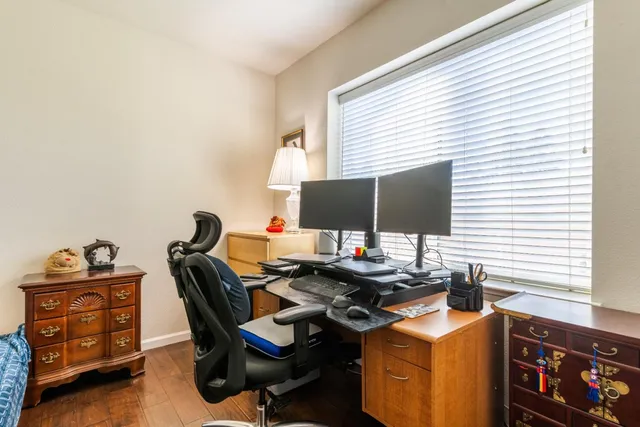 a view of a workspace with furniture and a window