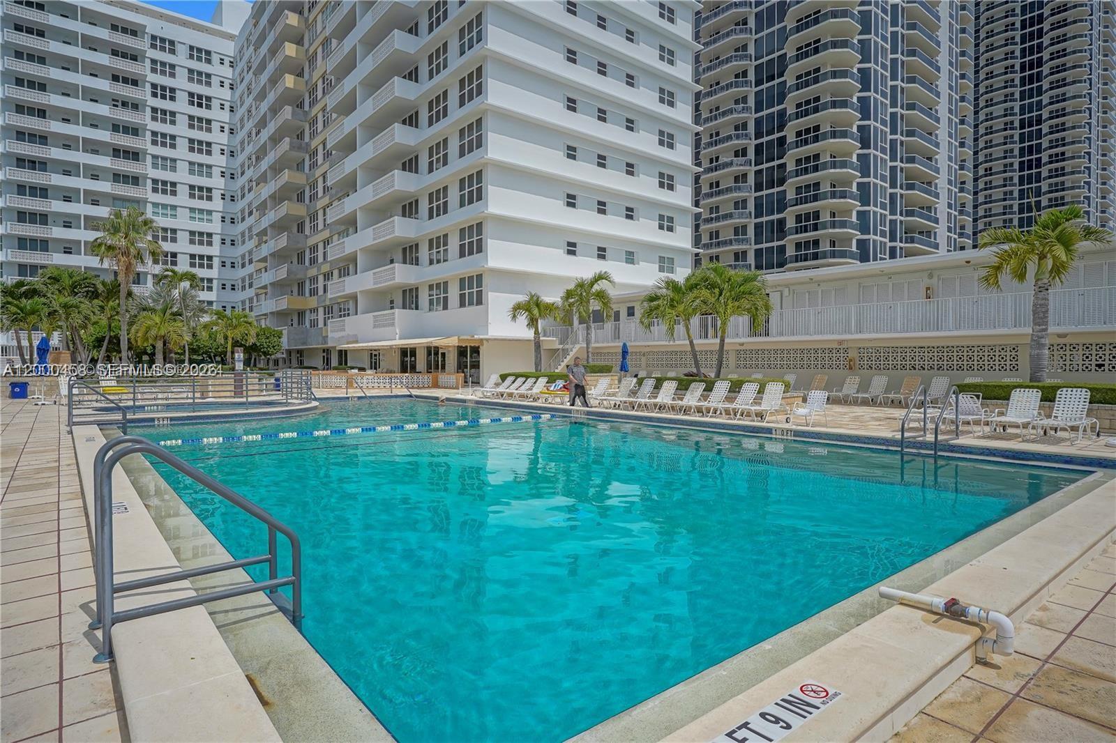 4747 Collins Avenue, Unit 1108 Miami Beach, FL 33140 - Photo 13 of 17 a swimming pool with outdoor view and trees