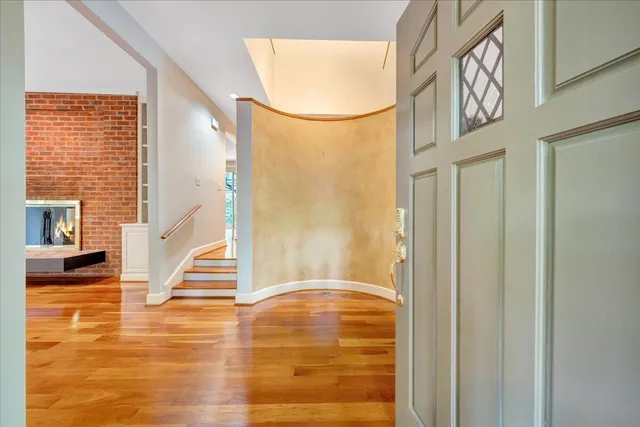 a view of empty room with wooden floor and fireplace