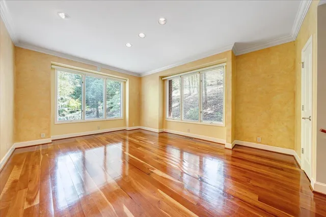 a view of a room with wooden floor and windows