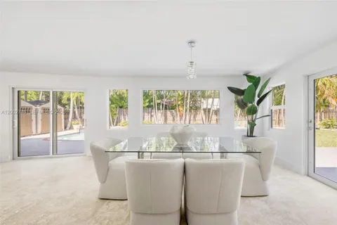 a dining room with furniture a chandelier and wooden floor