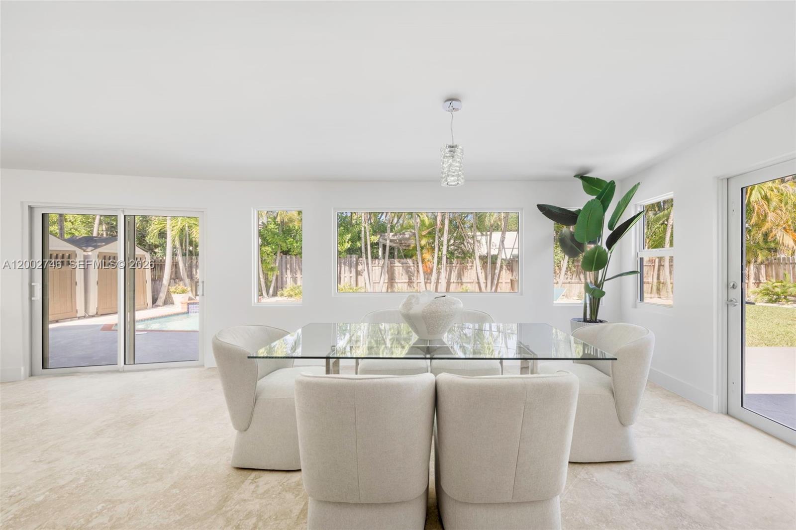 255 Ridgewood Road Key Biscayne, FL 33149 - Photo 12 of 30 a dining room with furniture a chandelier and wooden floor