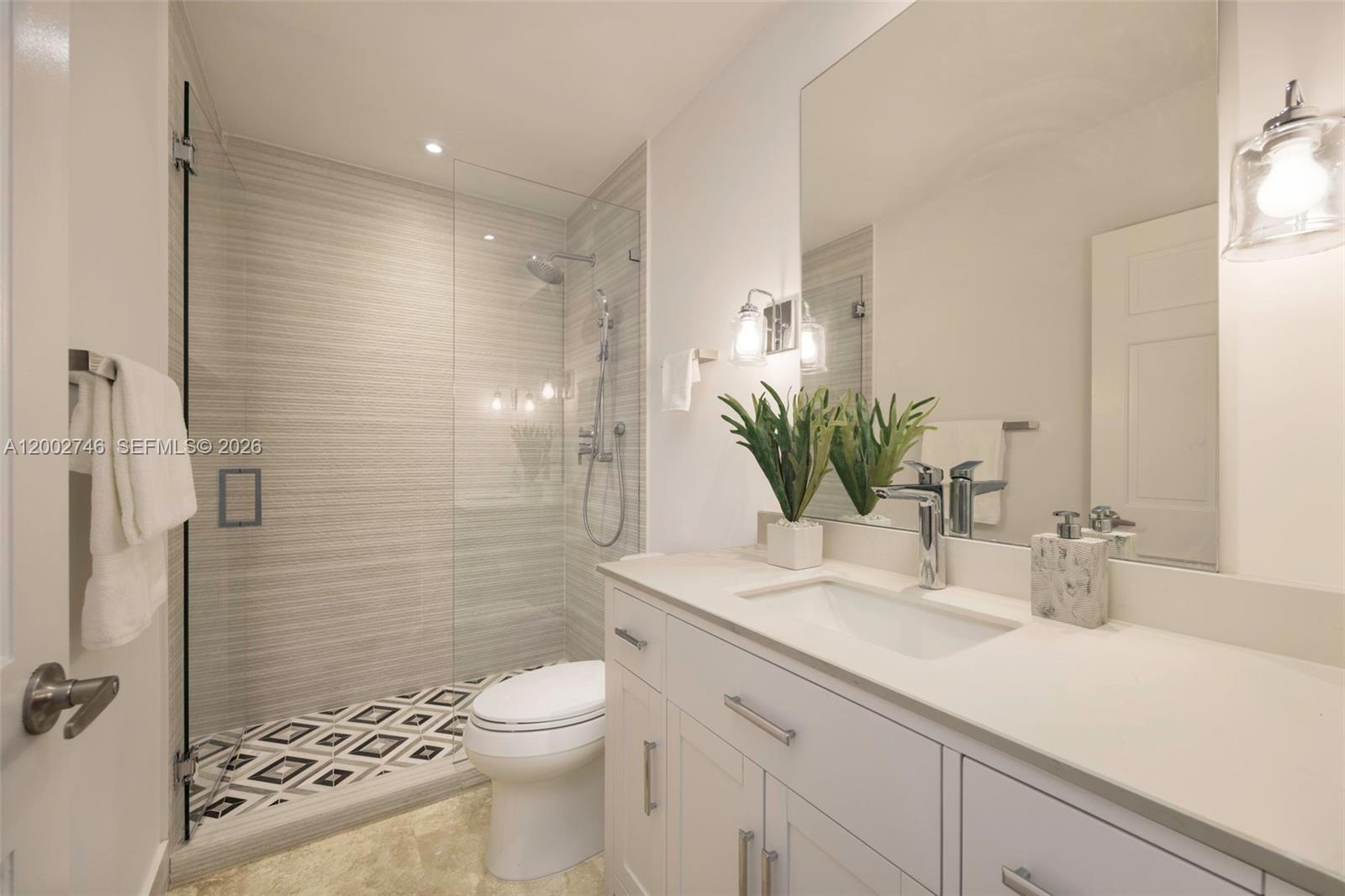 255 Ridgewood Road Key Biscayne, FL 33149 - Photo 22 of 30 a bathroom with a granite countertop sink a toilet and shower