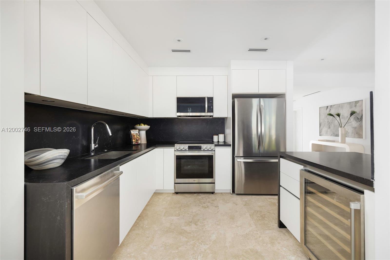 255 Ridgewood Road Key Biscayne, FL 33149 - Photo 7 of 30 a kitchen with stainless steel appliances kitchen island granite countertop a stove and a refrigerator