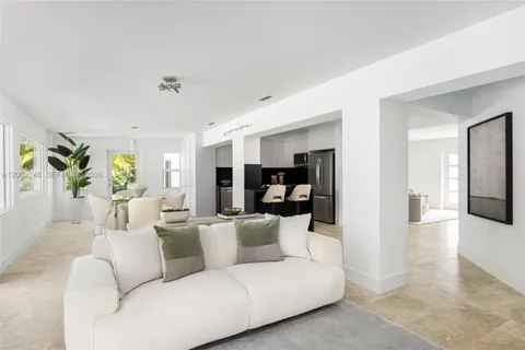 a living room with furniture white wooden floor and a rug