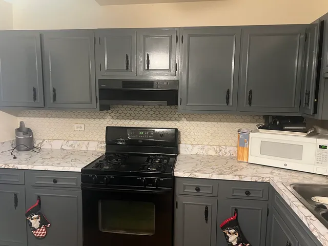 a kitchen with granite countertop a stove sink and cabinets