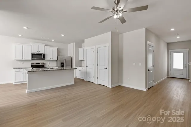 a view of kitchen with granite countertop cabinets and refrigerator