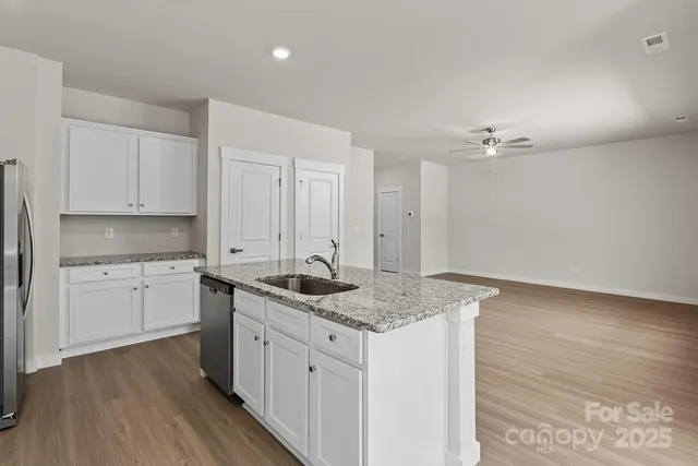 a kitchen with a sink cabinets and wooden floor