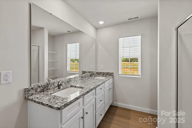 a bathroom with a granite countertop sink and a window
