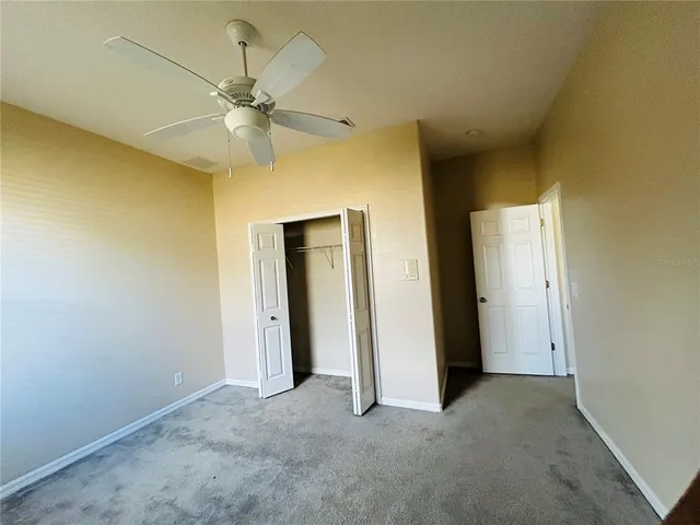an empty room with a ceiling fan and a window