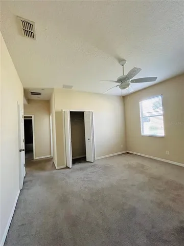an empty room with fan and windows