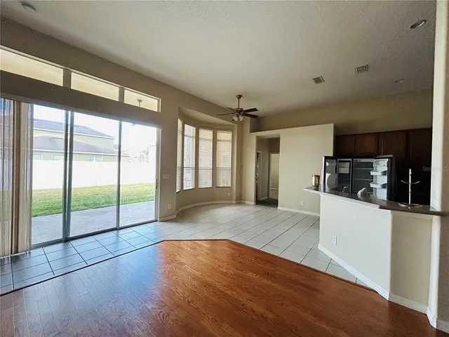 a view of a hallway with wooden floor and a living room