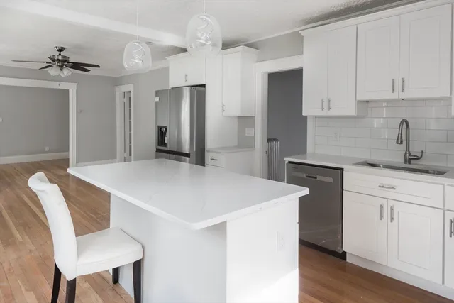 a kitchen with a table chairs sink and cabinets