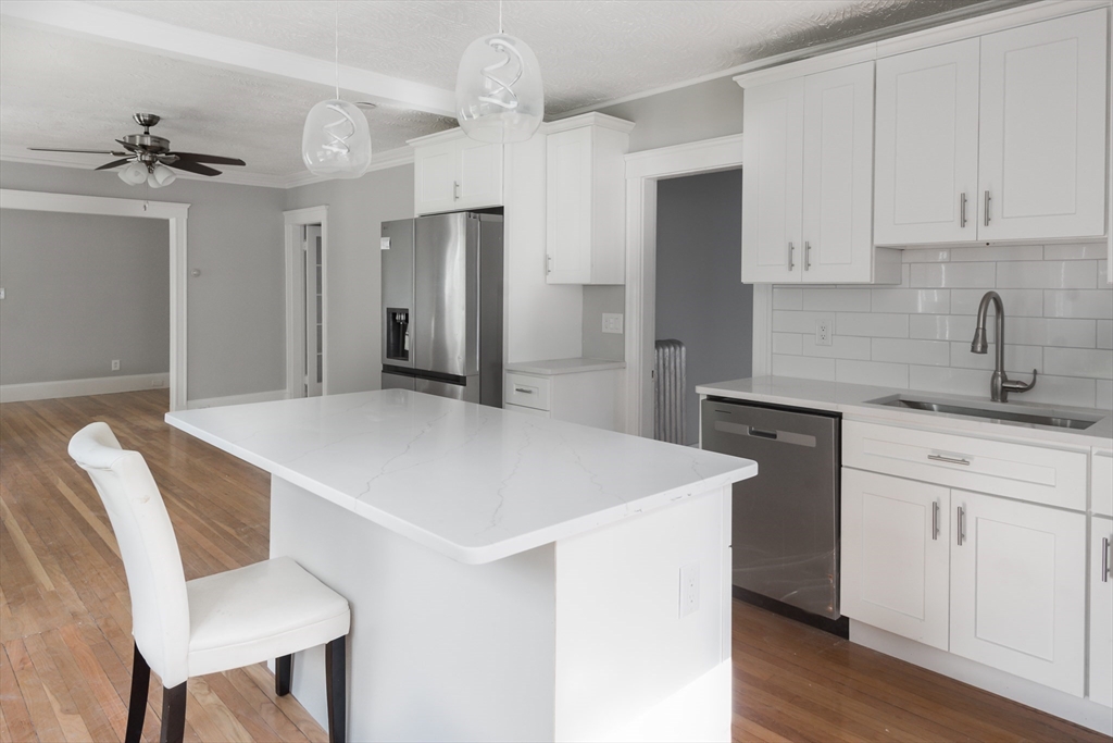 a kitchen with a table chairs sink and cabinets