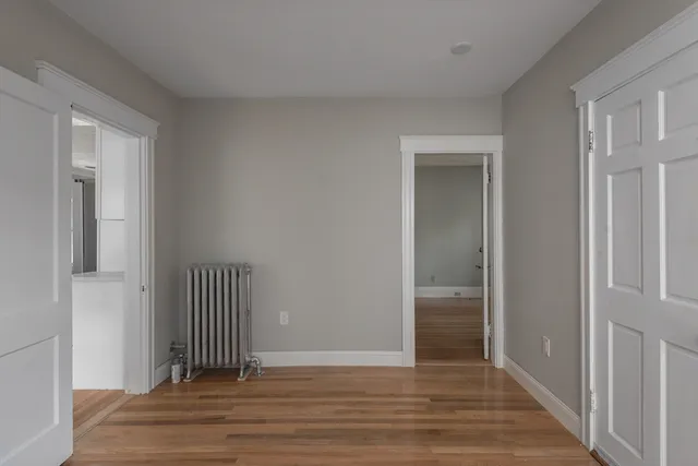 a view of a hallway with wooden floor and closet area