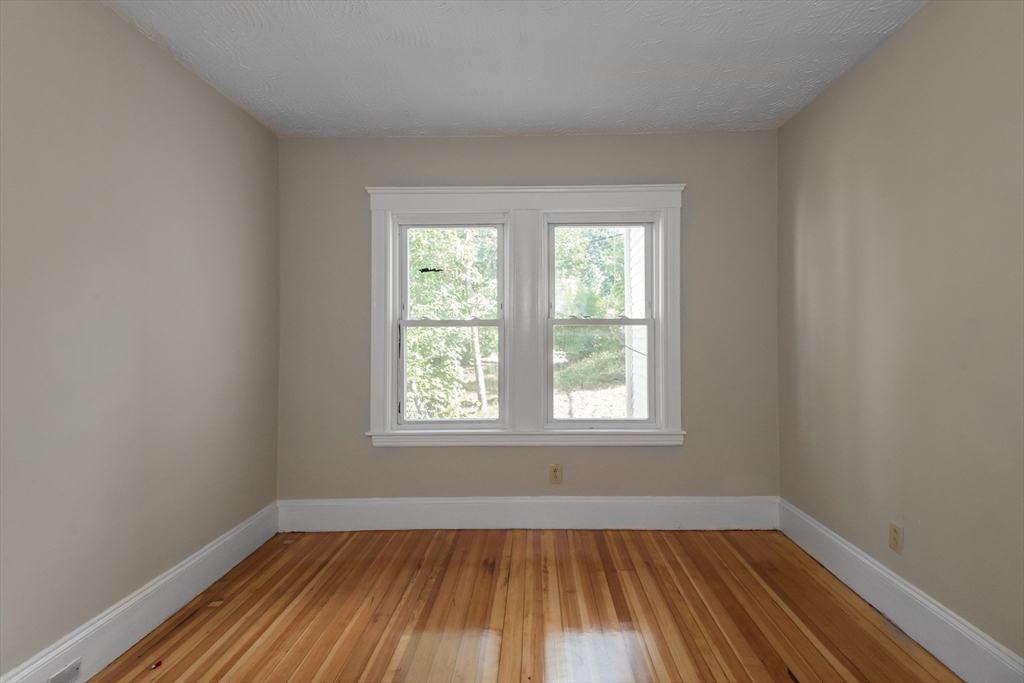 112 Brush Hill Road Milton, MA 02186 - Photo 13 of 42 an empty room with wooden floor and windows
