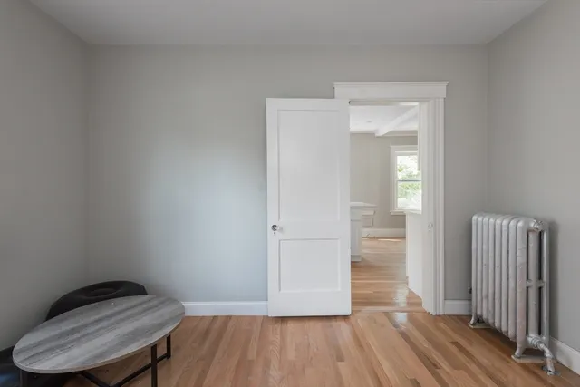 a view of a hallway with wooden floor and closet