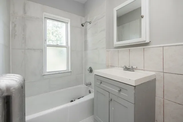 a bathroom with a sink toilet vanity and tub