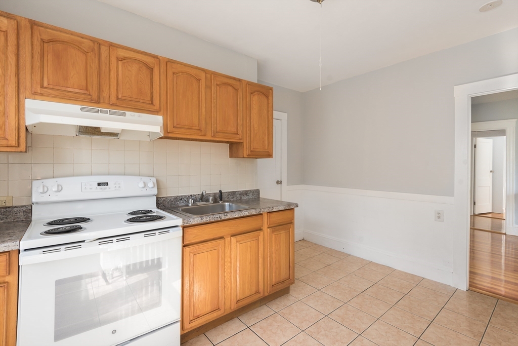 112 Brush Hill Road Milton, MA 02186 - Photo 18 of 42 a kitchen with a stove top oven sink and cabinets