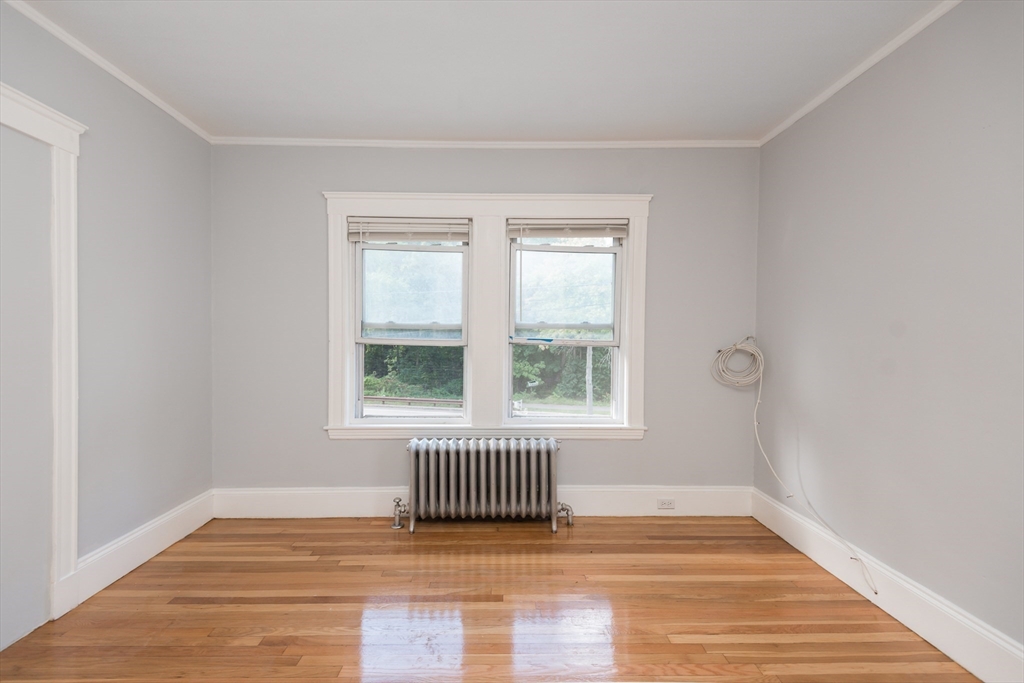 112 Brush Hill Road Milton, MA 02186 - Photo 20 of 42 a view of an empty room with wooden floor and a window
