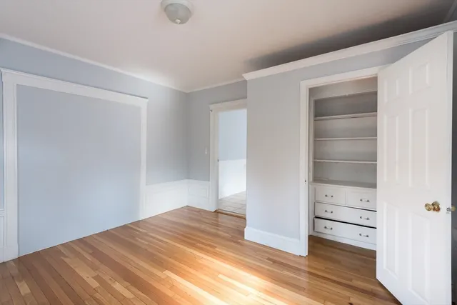 a view of empty room with wooden floor