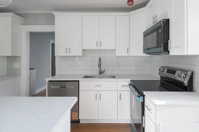 a kitchen with stainless steel appliances a stove a sink a refrigerator and cabinets