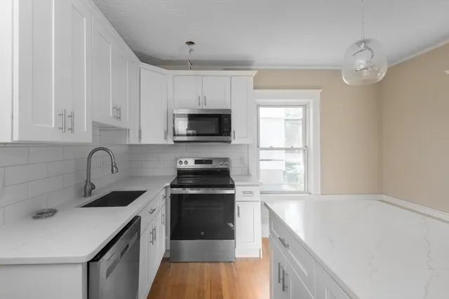 a kitchen with a sink stove top oven and cabinets