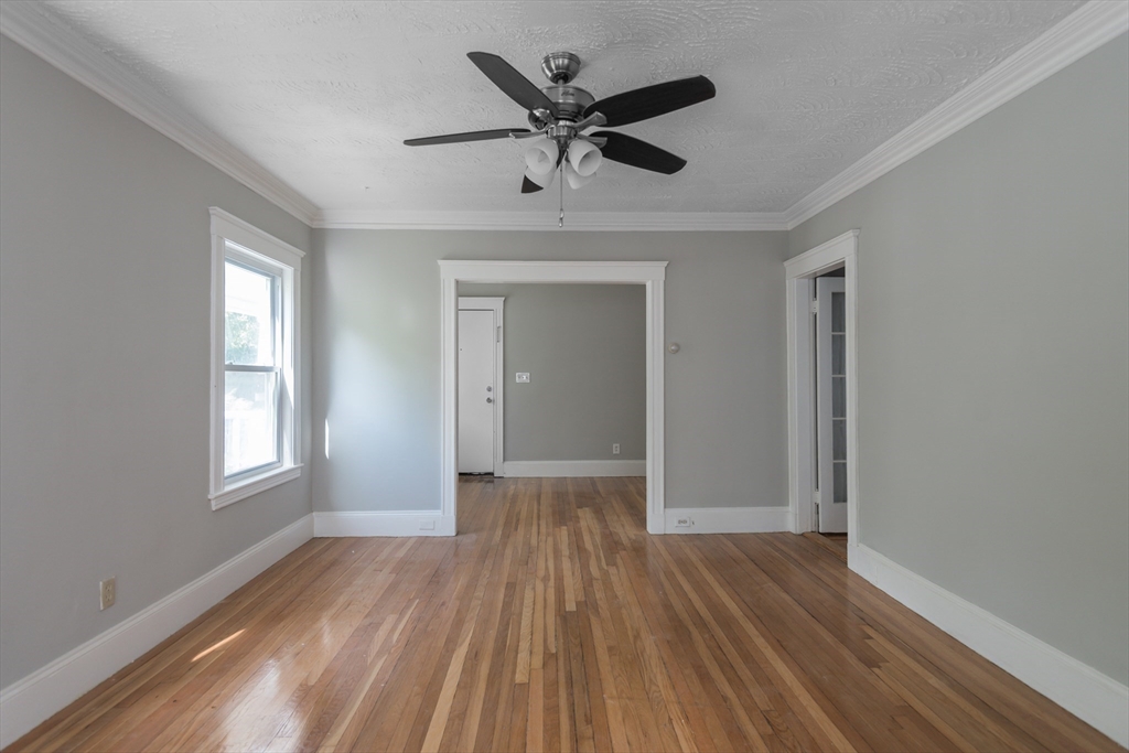 112 Brush Hill Road Milton, MA 02186 - Photo 10 of 42 a view of empty room with wooden floor and ceiling fan