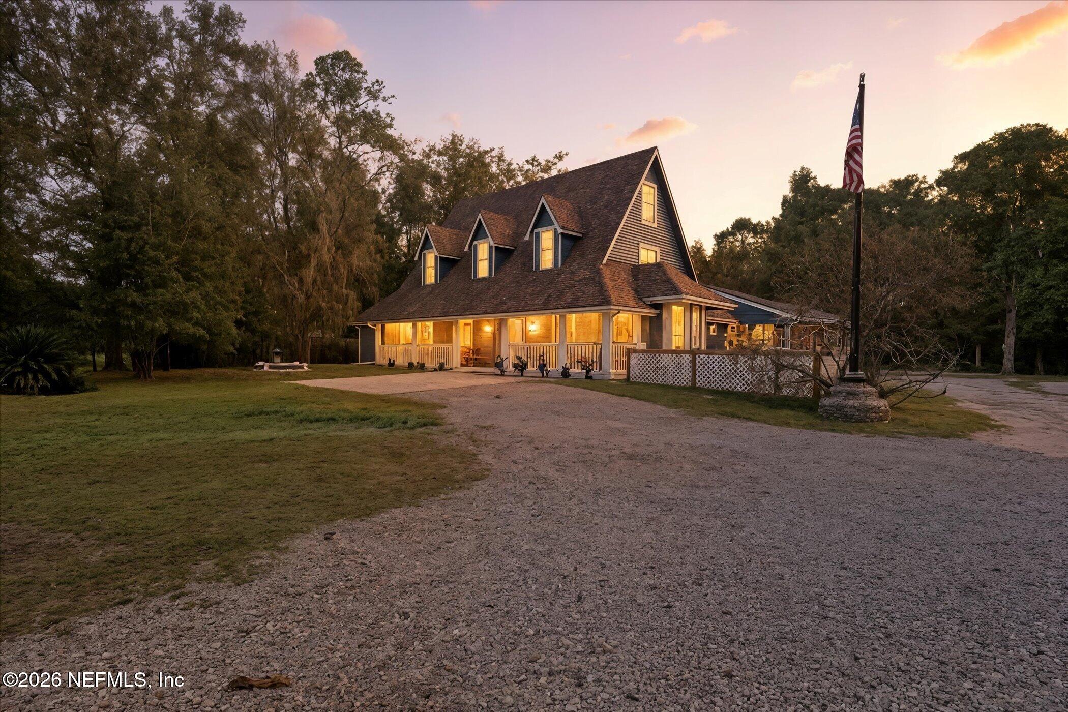 a view of an house with backyard and trees