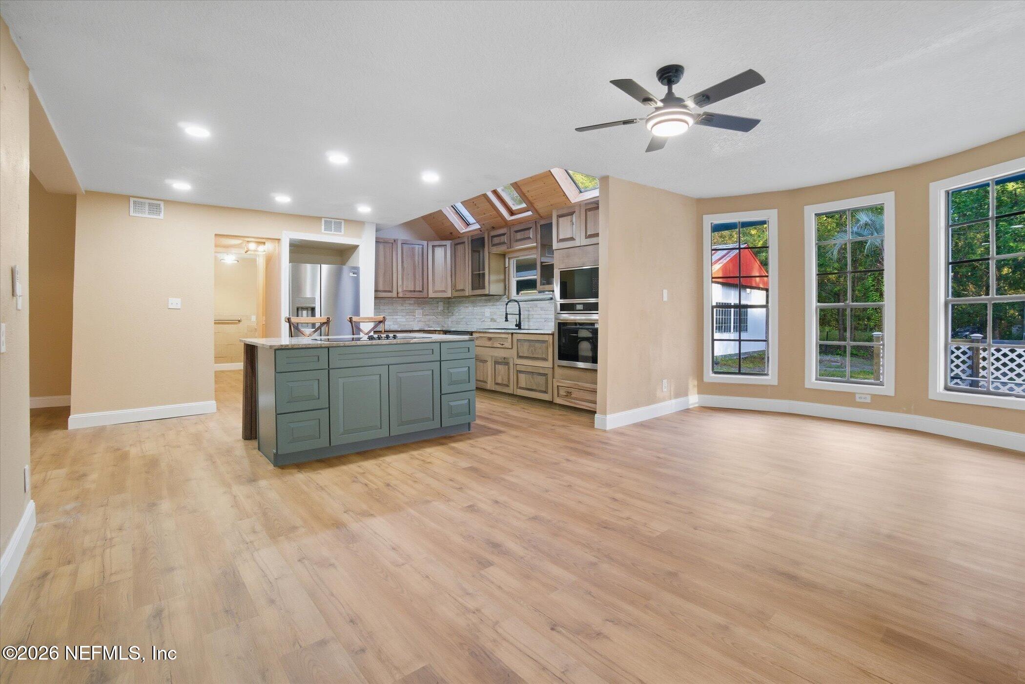 3121 Lannie Road Jacksonville, FL 32218 - Photo 17 of 68 a view of kitchen with stainless steel appliances granite countertop a stove top oven a sink and a refrigerator with wooden floor