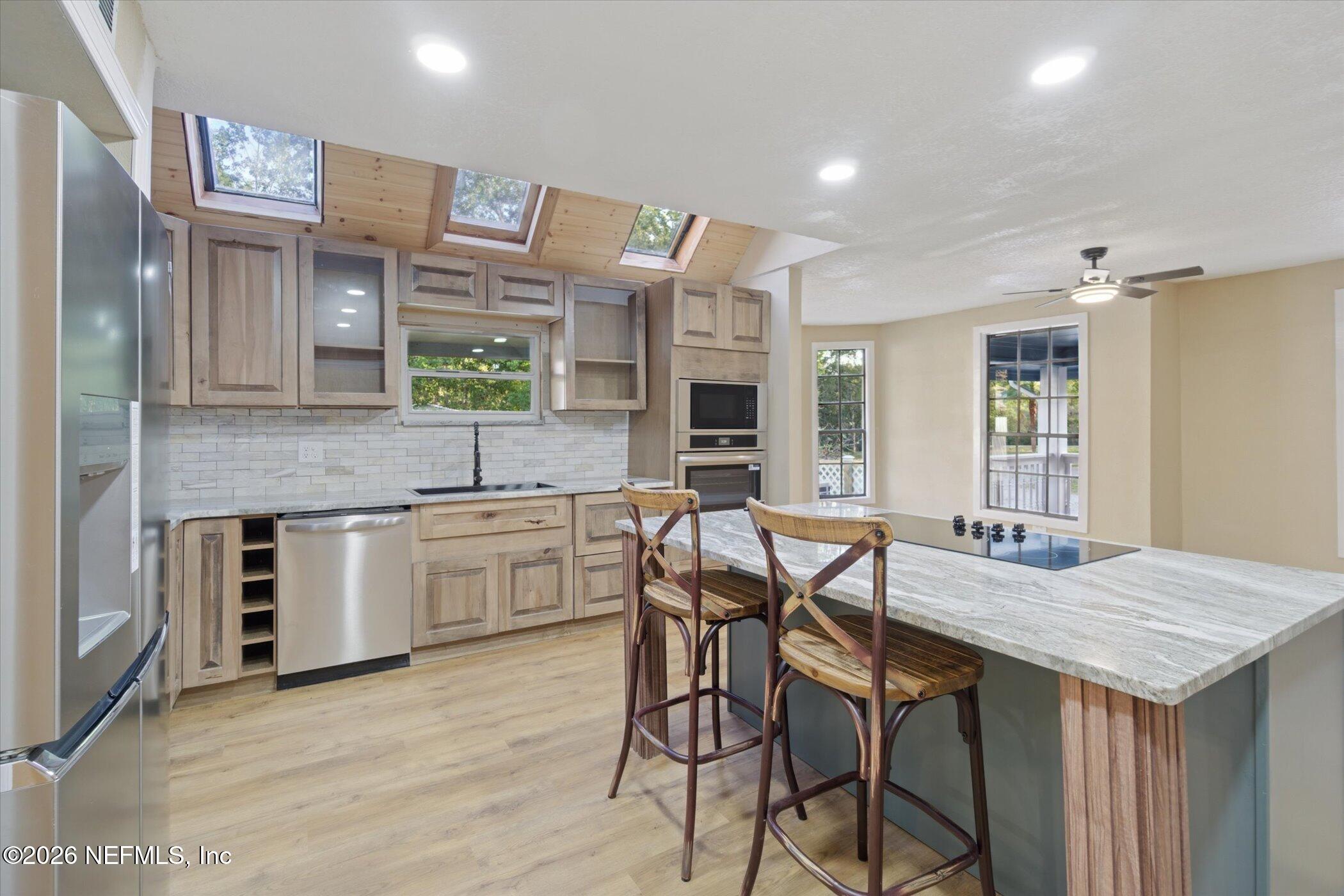 3121 Lannie Road Jacksonville, FL 32218 - Photo 19 of 68 a kitchen with stainless steel appliances kitchen island granite countertop a stove a sink and a refrigerator