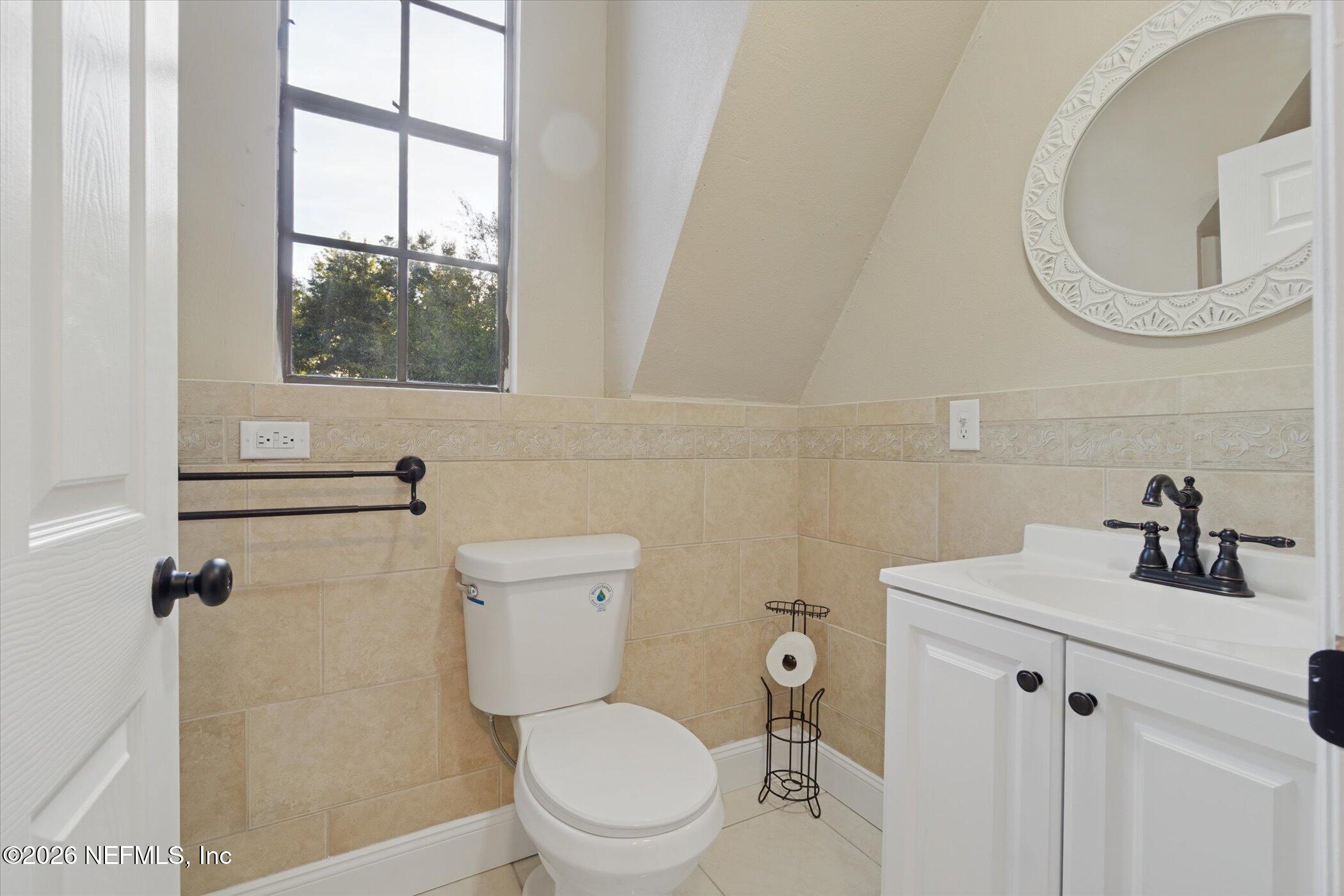 3121 Lannie Road Jacksonville, FL 32218 - Photo 42 of 68 a bathroom with a toilet a sink a mirror and a window