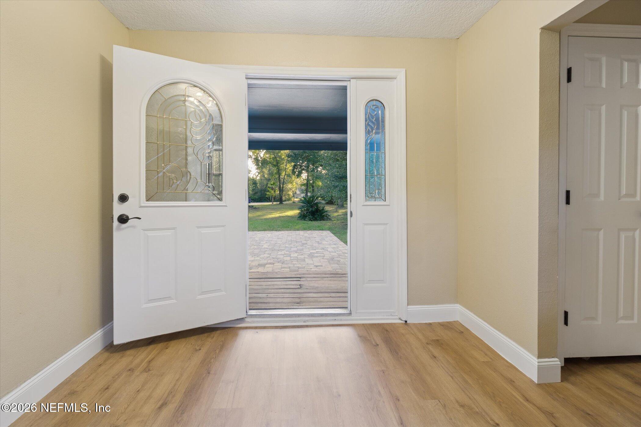 3121 Lannie Road Jacksonville, FL 32218 - Photo 10 of 68 an empty room with wooden floor mirror and windows