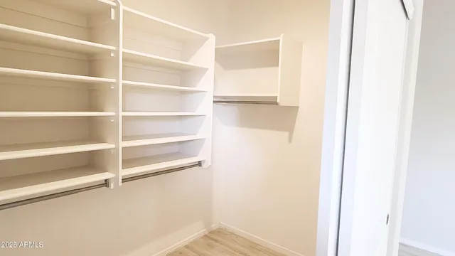 a view of walk in closet with empty racks