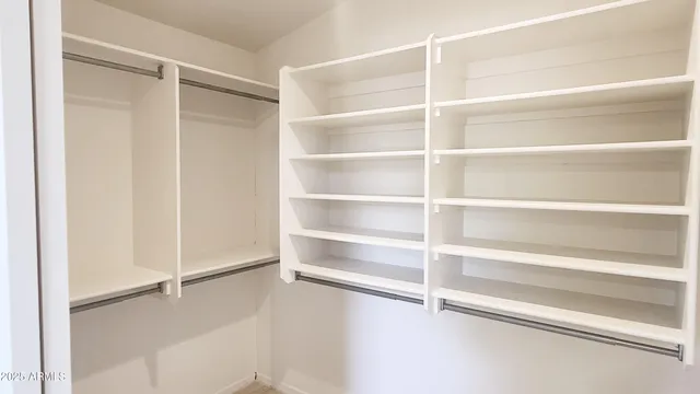 a view of walk in closet with empty racks