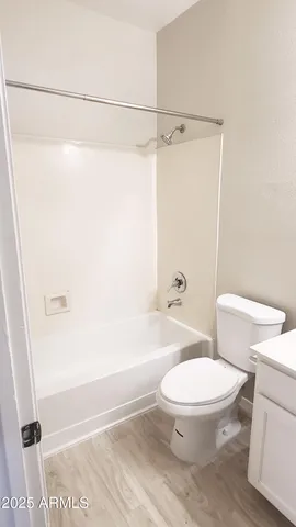 a white toilet sitting next to a bath tub