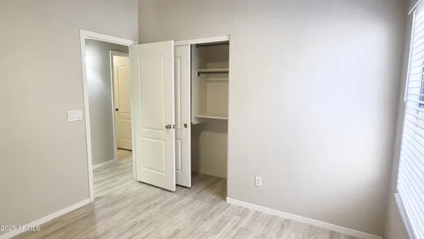 an empty room with wooden floor and closet