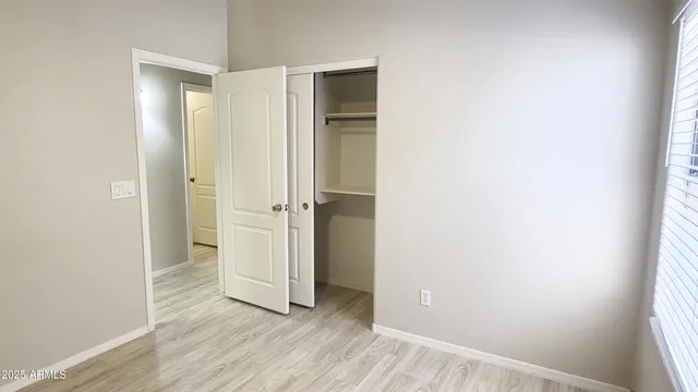 an empty room with wooden floor and closet