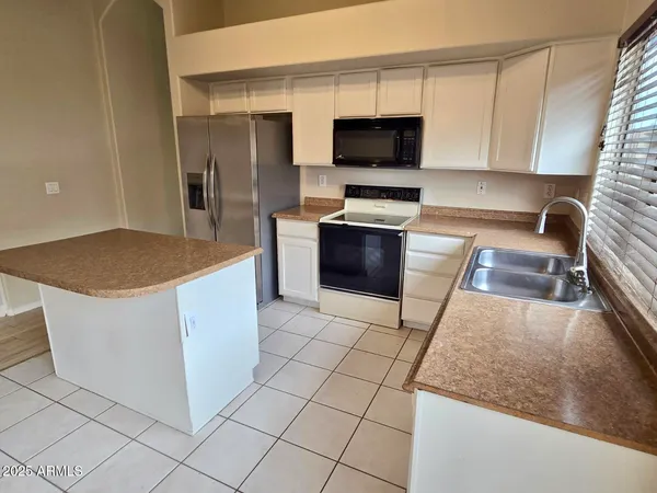 a kitchen with stainless steel appliances granite countertop a sink a stove a microwave and a refrigerator