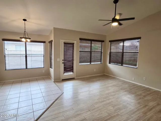a view of an empty room with a window and chandelier